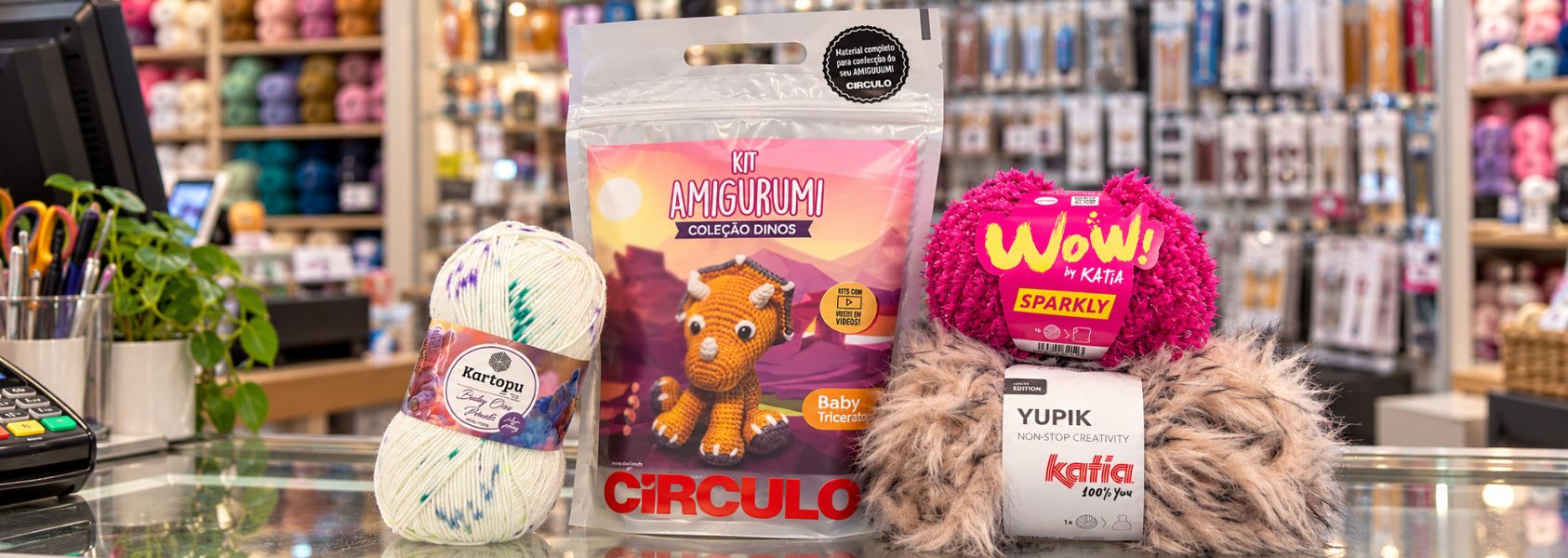 Kit amigurumi Círculo de triceratops con lanas Kartopu y Katia sobre el mostrador de una tienda de lanas de Modista. 