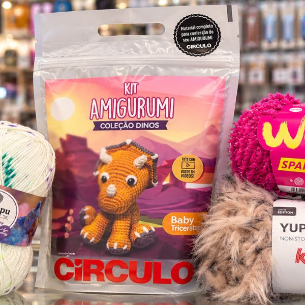 Kit amigurumi Círculo de triceratops con lanas Kartopu y Katia sobre el mostrador de una tienda de lanas de Modista. 